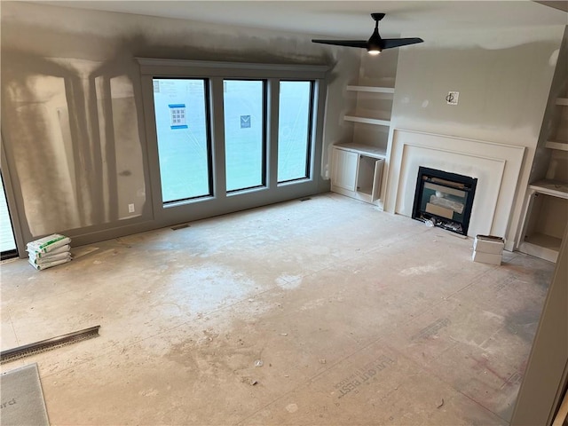 7080 NW Forest Lakes Dr, Parkville, MO 64152 - unfurnished living room with a ceiling fan and a glass covered fireplace
