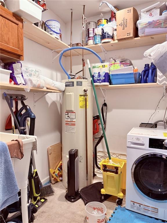 901-B E 2nd St, Trenton, MO 64683 - clothes washing area with washer / dryer, water heater, carpet floors, and cabinet space