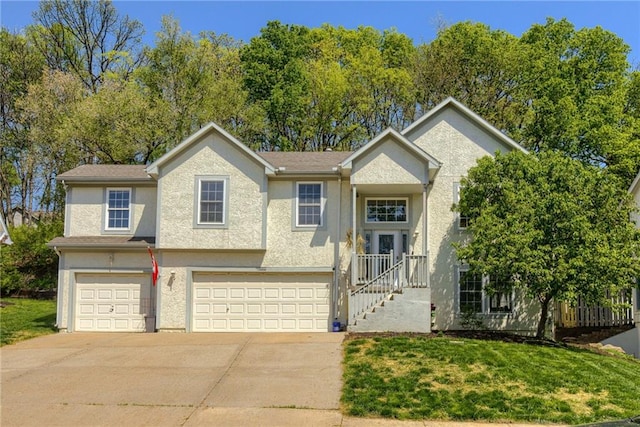 view of front facade with stucco siding, a front lawn, driveway, and a garage