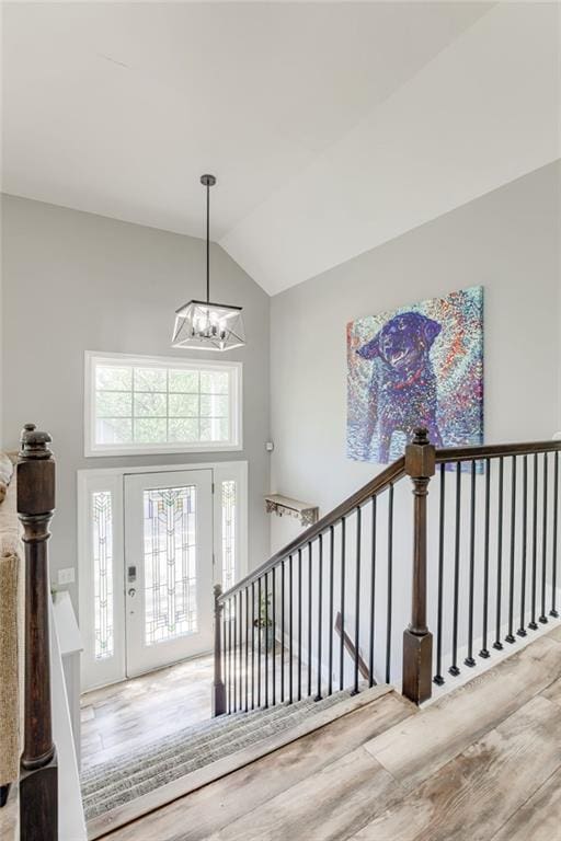 foyer entrance with a chandelier, wood finished floors, and high vaulted ceiling