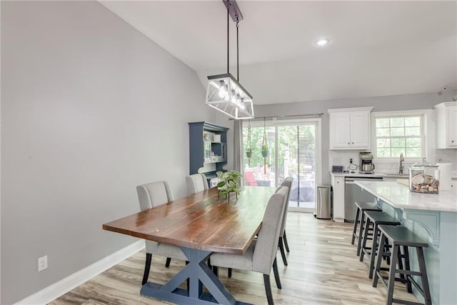 dining room featuring light wood finished floors, vaulted ceiling, baseboards, and recessed lighting