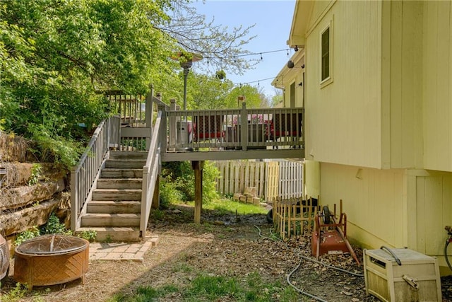 view of play area with a wooden deck, stairs, and an outdoor fire pit