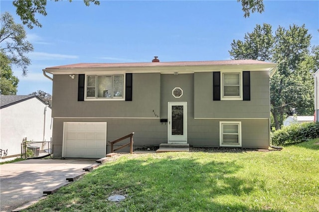 split foyer home featuring a garage, a front lawn, and concrete driveway