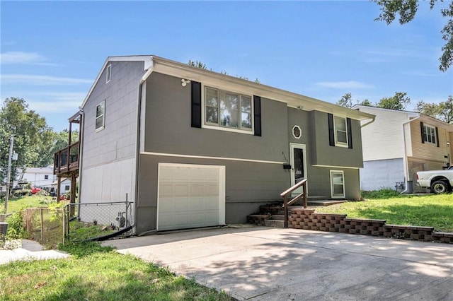 bi-level home featuring a garage and concrete driveway