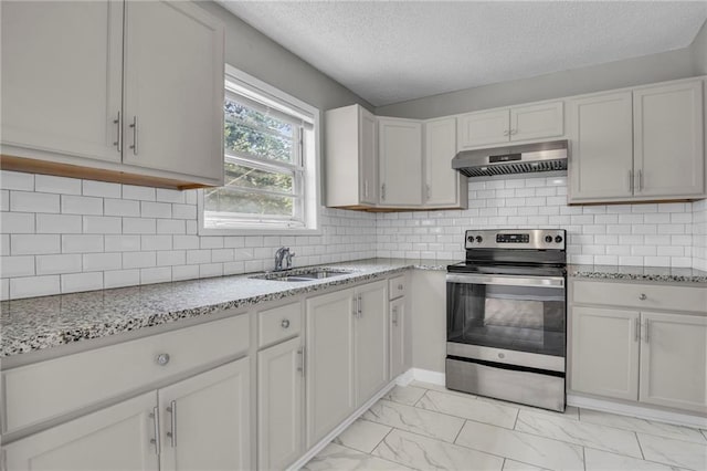 kitchen with stainless steel electric range, under cabinet range hood, a sink, light marble finish floors, and a textured ceiling