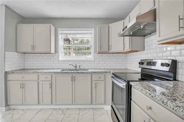 kitchen featuring under cabinet range hood, electric stove, a sink, light marble finish floors, and a textured ceiling