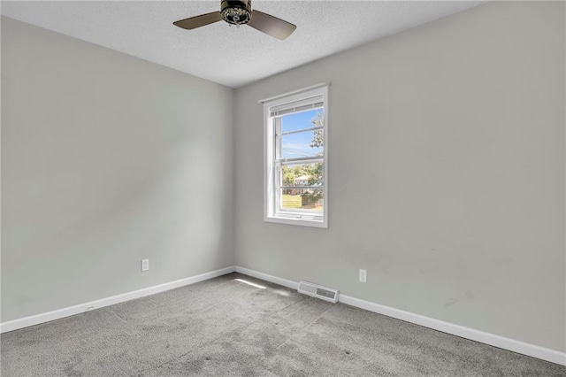 carpeted spare room featuring baseboards, a textured ceiling, and ceiling fan