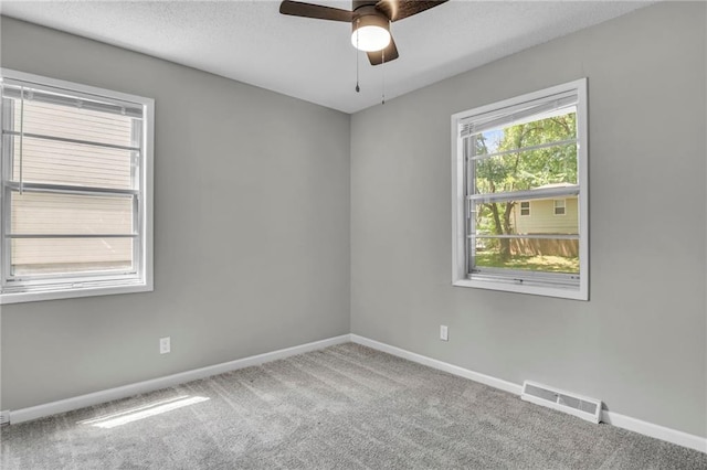 spare room with carpet, ceiling fan, baseboards, and a textured ceiling