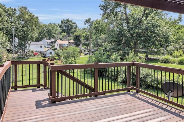 wooden terrace featuring a lawn and view of wooded area