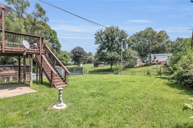 view of yard featuring stairway, a deck, and a trampoline