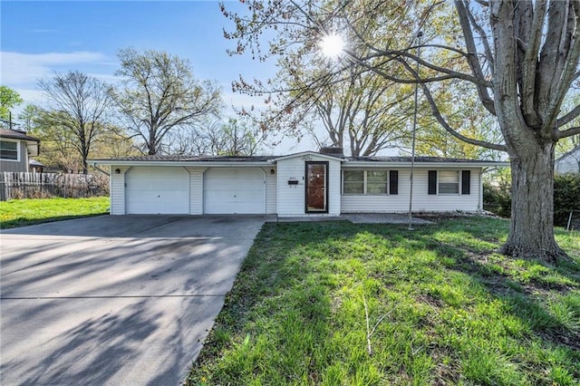 ranch-style home with an attached garage, driveway, fence, and a front yard
