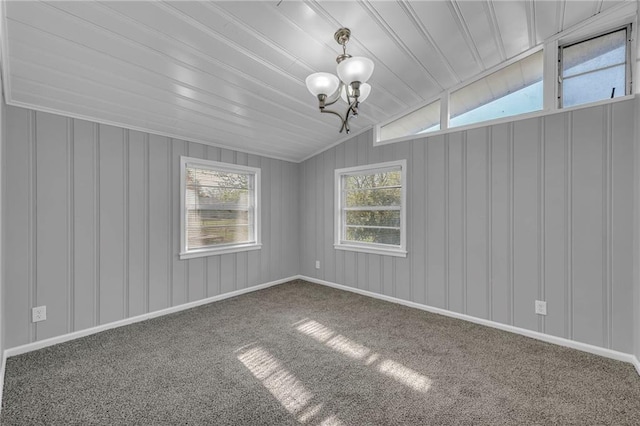 unfurnished room featuring a chandelier, carpet, and a wealth of natural light