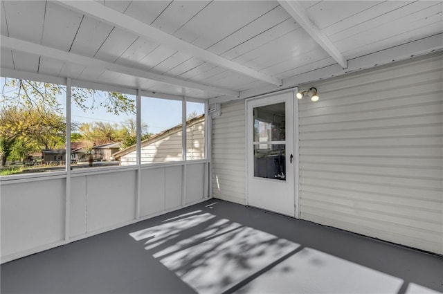 unfurnished sunroom with beamed ceiling and plenty of natural light