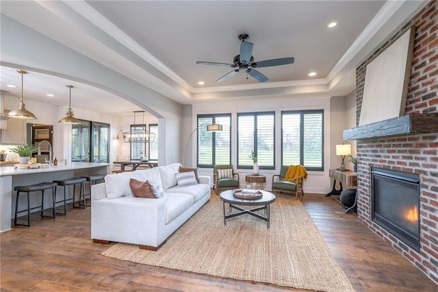 8120 Lone Elm Rd, Lenexa, KS 66220 - living room featuring dark wood-type flooring, a fireplace, a tray ceiling, ceiling fan, and recessed lighting