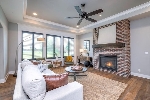 8120 Lone Elm Rd, Lenexa, KS 66220 - living room with wood finished floors, a brick fireplace, a tray ceiling, crown molding, and recessed lighting