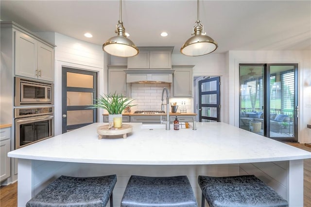 8120 Lone Elm Rd, Lenexa, KS 66220 - kitchen with stainless steel appliances, gray cabinets, a breakfast bar area, pendant lighting, and recessed lighting