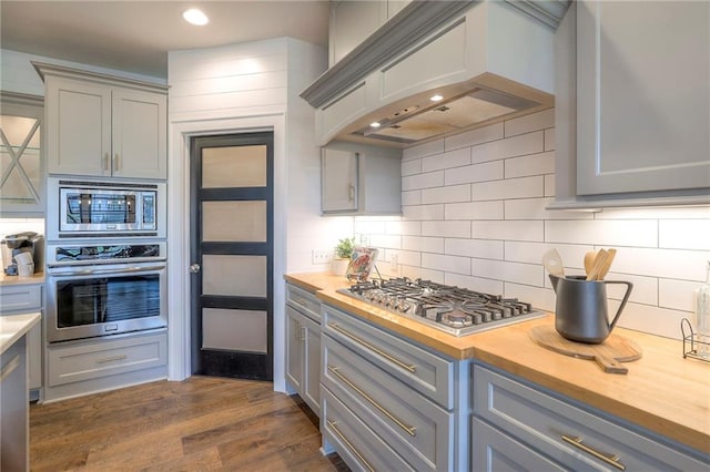 8120 Lone Elm Rd, Lenexa, KS 66220 - kitchen with appliances with stainless steel finishes, gray cabinets, premium range hood, wooden counters, and decorative backsplash