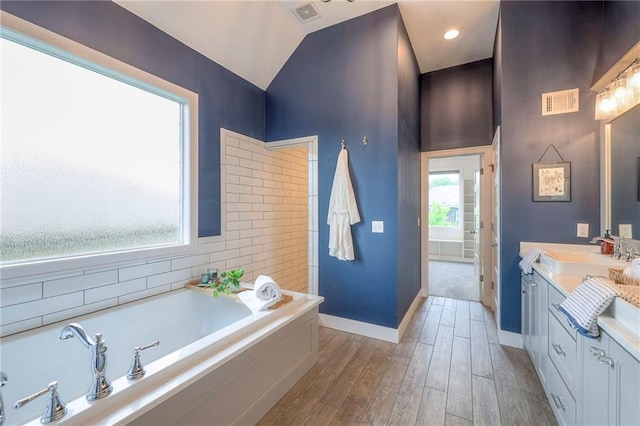 8120 Lone Elm Rd, Lenexa, KS 66220 - bathroom featuring a garden tub, vanity, wood finished floors, baseboards, and lofted ceiling