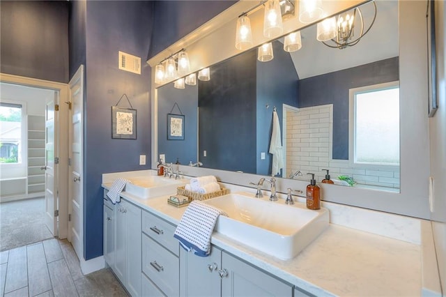 8120 Lone Elm Rd, Lenexa, KS 66220 - bathroom with double vanity, a chandelier, and wood finished floors