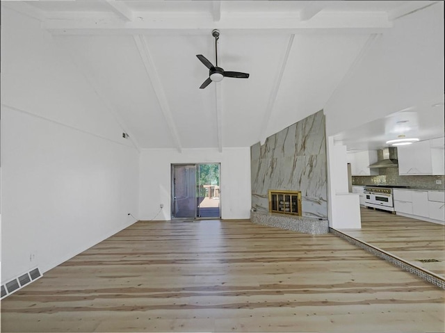 3214 S Hawthorne Ave, Independence, MO 64052 - unfurnished living room featuring beam ceiling, a fireplace, light wood-style flooring, high vaulted ceiling, and ceiling fan