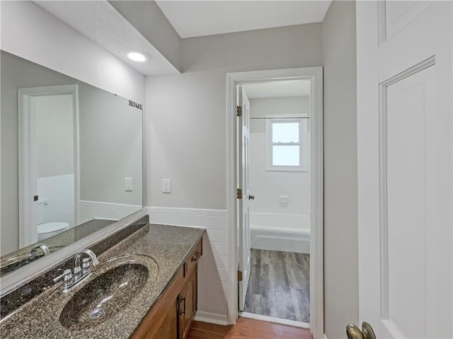 3214 S Hawthorne Ave, Independence, MO 64052 - bathroom with wood finished floors, vanity, a wainscoted wall, and toilet