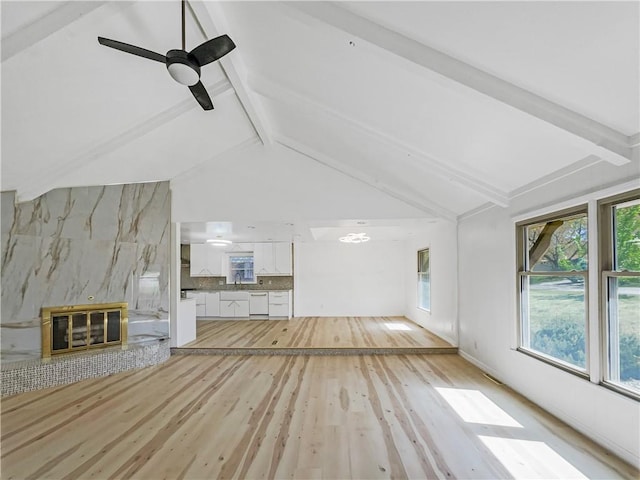 3214 S Hawthorne Ave, Independence, MO 64052 - unfurnished living room featuring ceiling fan, vaulted ceiling with beams, and light wood-type flooring