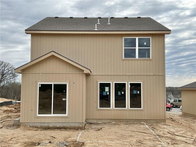 back of property featuring roof with shingles