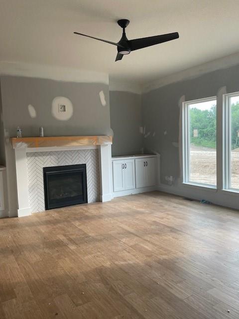 16291 Giorgia St, Parkville, MO 64152 - unfurnished living room featuring ceiling fan, a tiled fireplace, and wood finished floors