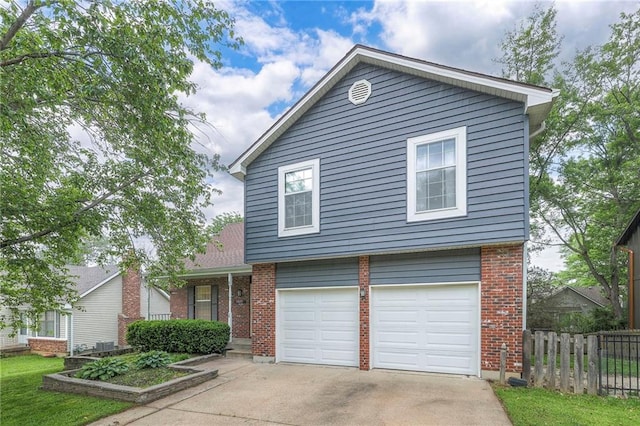 view of front of home with fence, driveway, brick siding, and a garage