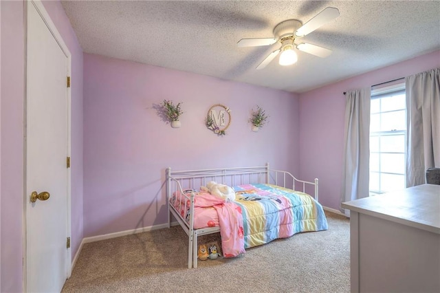 carpeted bedroom with a textured ceiling, a ceiling fan, and baseboards