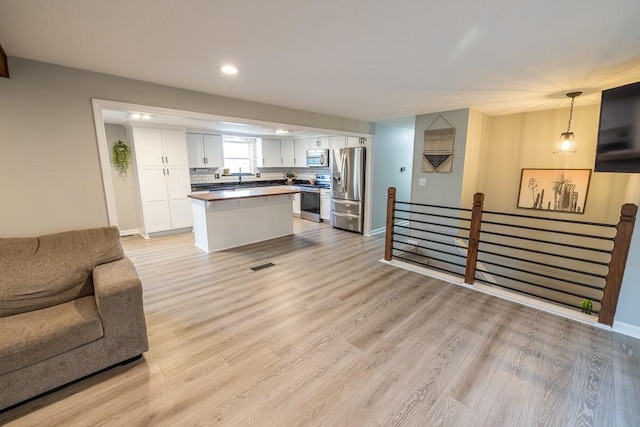 20609 NE 161st St, Kearney, MO 64060 - kitchen with open floor plan, recessed lighting, white cabinets, light wood finished floors, and stainless steel appliances