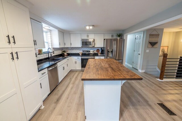 20609 NE 161st St, Kearney, MO 64060 - kitchen with appliances with stainless steel finishes, a sink, a center island, decorative backsplash, and butcher block counters