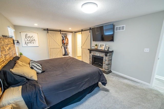 20609 NE 161st St, Kearney, MO 64060 - carpeted bedroom with a barn door, a textured ceiling, recessed lighting, baseboards, and visible vents