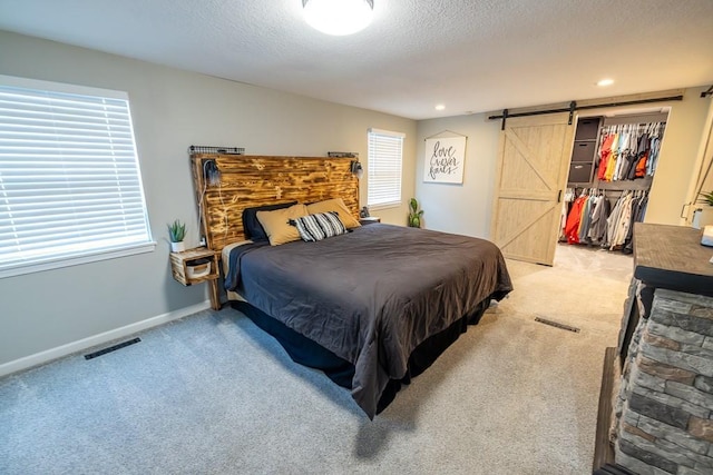 20609 NE 161st St, Kearney, MO 64060 - bedroom featuring light colored carpet, a barn door, a textured ceiling, baseboards, and visible vents