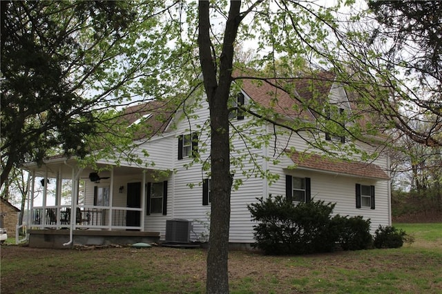 view of side of home with central AC, a porch, and a lawn