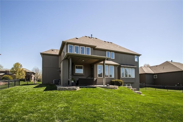 rear view of house featuring a fenced backyard and a yard