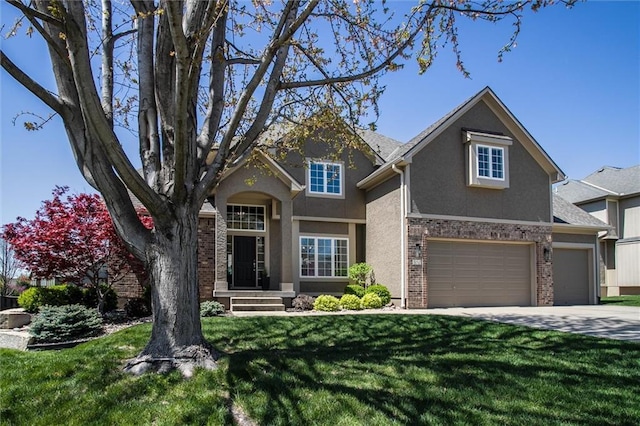 craftsman-style home with brick siding, a garage, stucco siding, a front yard, and driveway