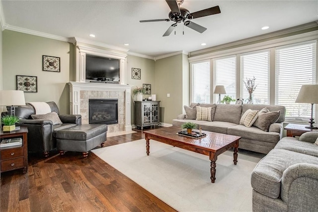 living area featuring ceiling fan, dark wood finished floors, ornamental molding, and a wealth of natural light