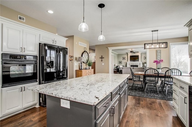 kitchen featuring visible vents, a kitchen island, dark wood-type flooring, gray cabinets, and black appliances