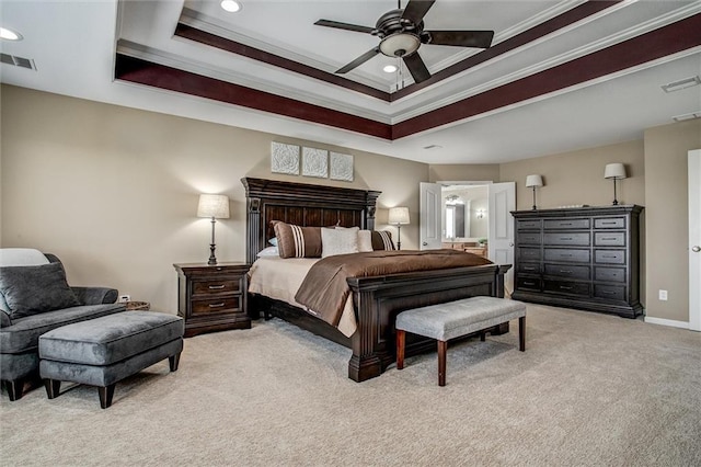 bedroom with light colored carpet, a raised ceiling, recessed lighting, visible vents, and ornamental molding