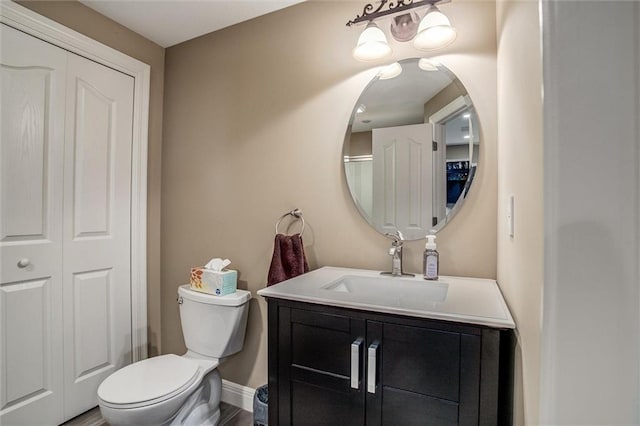 bathroom with vanity, baseboards, and toilet