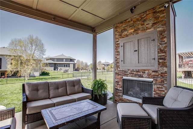 view of patio / terrace with a fenced backyard and an outdoor living space with a fireplace