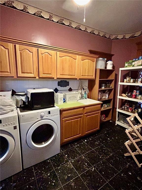 laundry room featuring independent washer and dryer and cabinet space