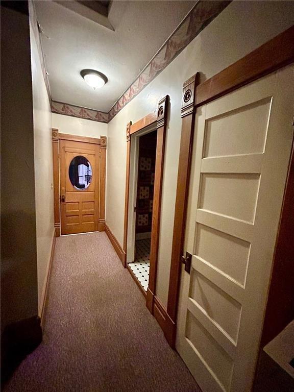 hall featuring carpet floors and baseboards