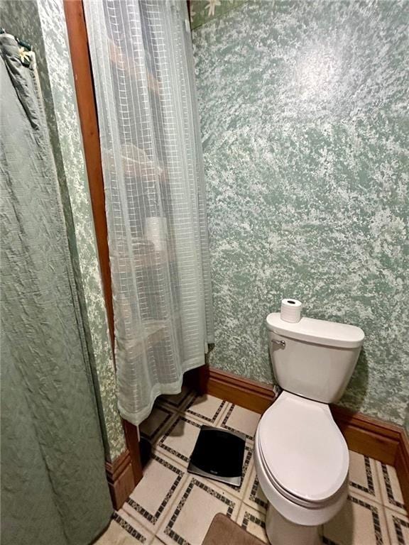 full bath featuring wallpapered walls, toilet, and baseboards