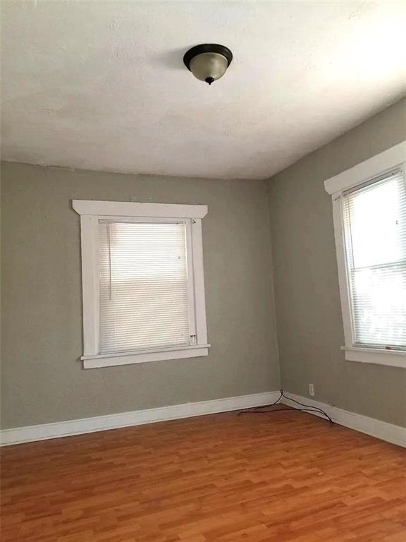 2109 E 58th St, Kansas City, MO 64130 - empty room with wood finished floors and baseboards