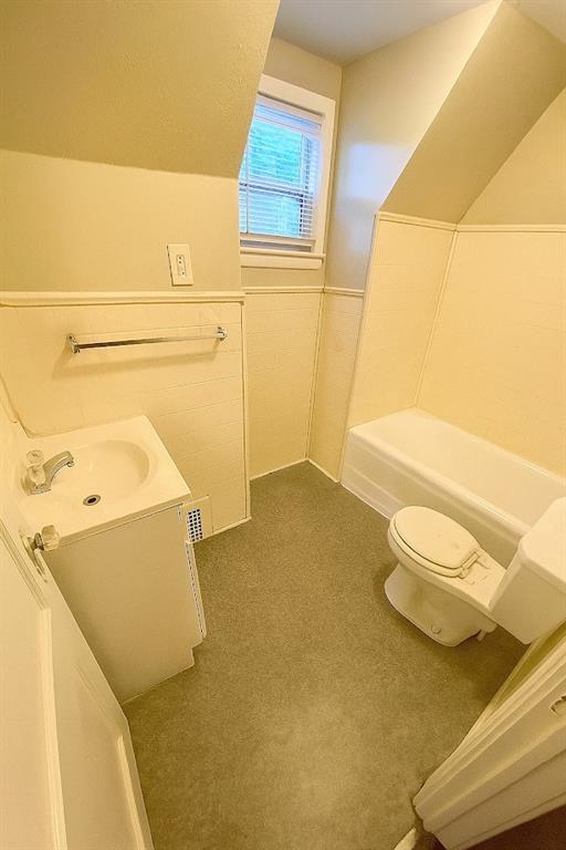 5610 Euclid Ave, Kansas City, MO 64130 - full bath featuring vanity, a tub to relax in, and a wainscoted wall