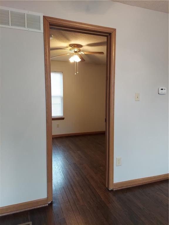 1610 S Northern Blvd, Independence, MO 64052 - empty room with a textured ceiling, ceiling fan, dark wood finished floors, baseboards, and visible vents