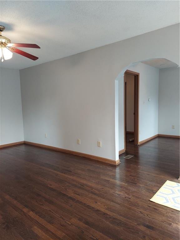 1610 S Northern Blvd, Independence, MO 64052 - spare room featuring arched walkways, baseboards, dark wood-type flooring, and ceiling fan
