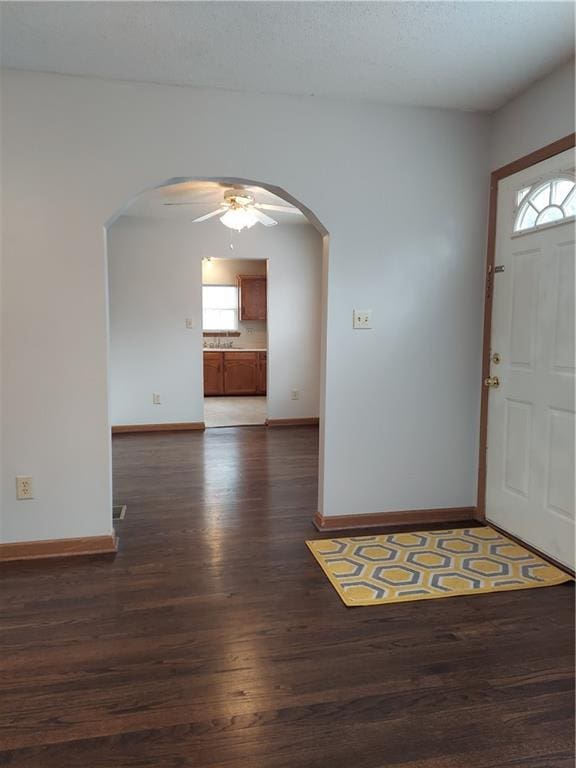 1610 S Northern Blvd, Independence, MO 64052 - entrance foyer with baseboards, dark wood-style floors, arched walkways, and ceiling fan